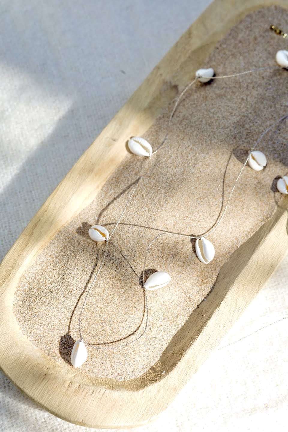 Bijou de créateur - baya fin de cauris tissés sur un fil doré avec un fermoir en acier inoxydable.