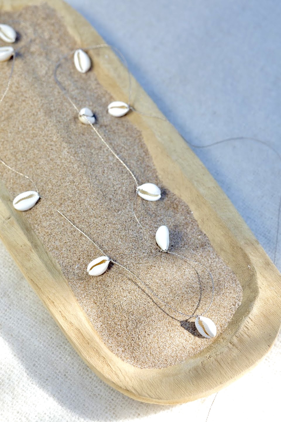 Baya CAORI avec des cauris véritables montés et tissés sur un fil doré très solide. Fermoir homard en acier inoxydable doré sans nickel sans plomb et sans cadmium, fait main sur mesure et ajusté a votre taille, résistant à l'eau