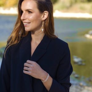 Bracelets élastiques OREA en perles de verre japonaise blanc ivoire brillant et doré porté en trio avec le coloris marron glacé et saumon nacré fait main porté avec les boucles d'oreilles ELEA acier inoxydable et charm pendentif croix catholique chrétienne en nacre blanche