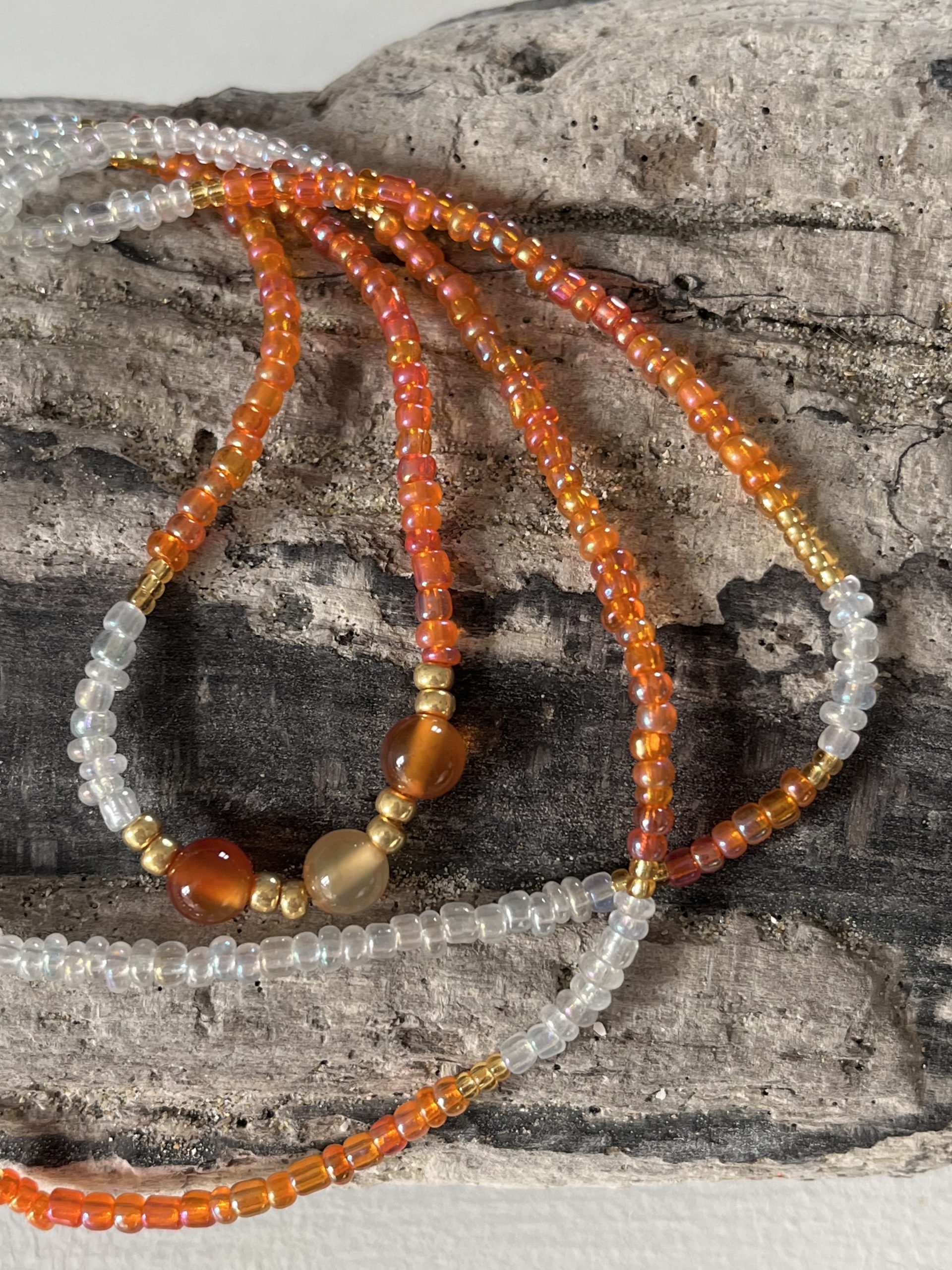 Baya bin bin élastique Soléia Tria en perles de verre orange vif reflets lumineux et perles transparentes cristal dorées japonaises miyuki et pierres naturelles agate cornaline veritables fait main et sur mesure ajusté a la ma taille bijou de l'été à porter autour de la taille