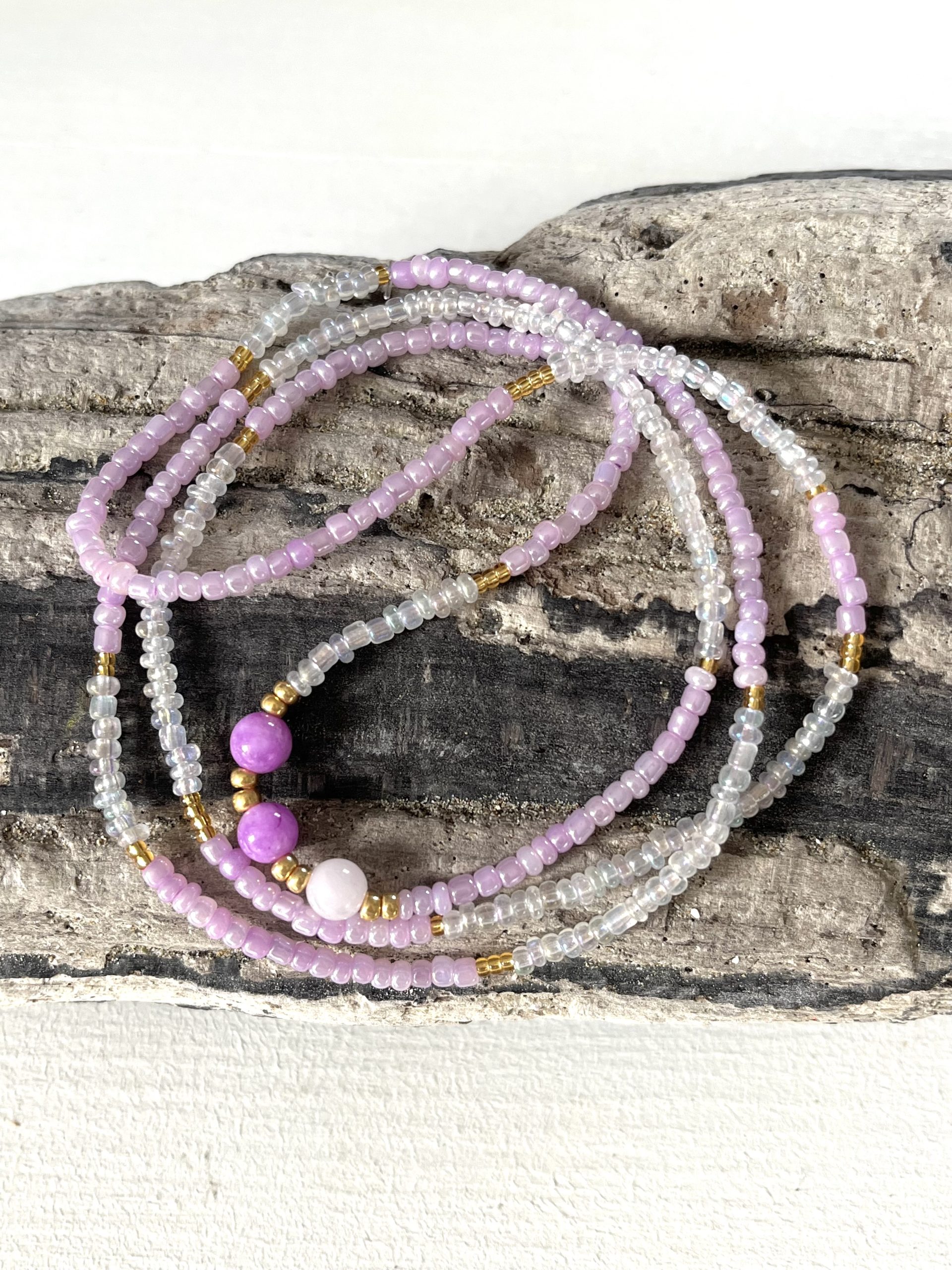 Baya bin bin élastique Soléia Tria en perles de verre mauve lilas nacré et perles de verre blanches et dorées japonaises miyuki et pierres naturelles agate mauve violette et Quartz rose veritables fait main et sur mesure ajusté a la ma taille bijou de l'été à porter autour de la taille