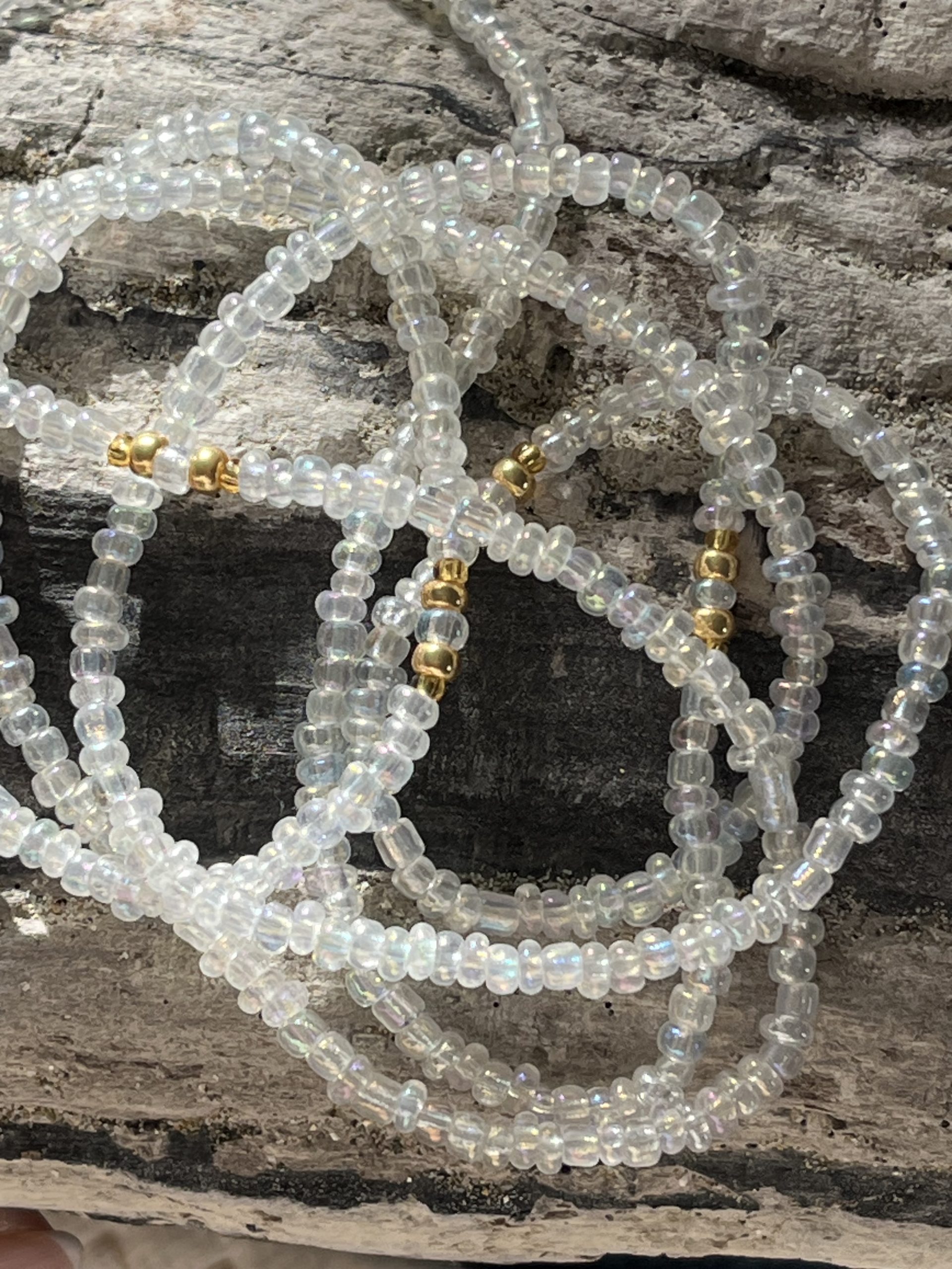 Baya ou bin bin élastique Soléia en perles de verre de coloris transparent cristal clear lumineux aux reflets lumineux et perles dorées japonaises miyuki très résistantes fait main et sur mesure ajusté a la ma taille bijou de l'été à porter autour de la taille