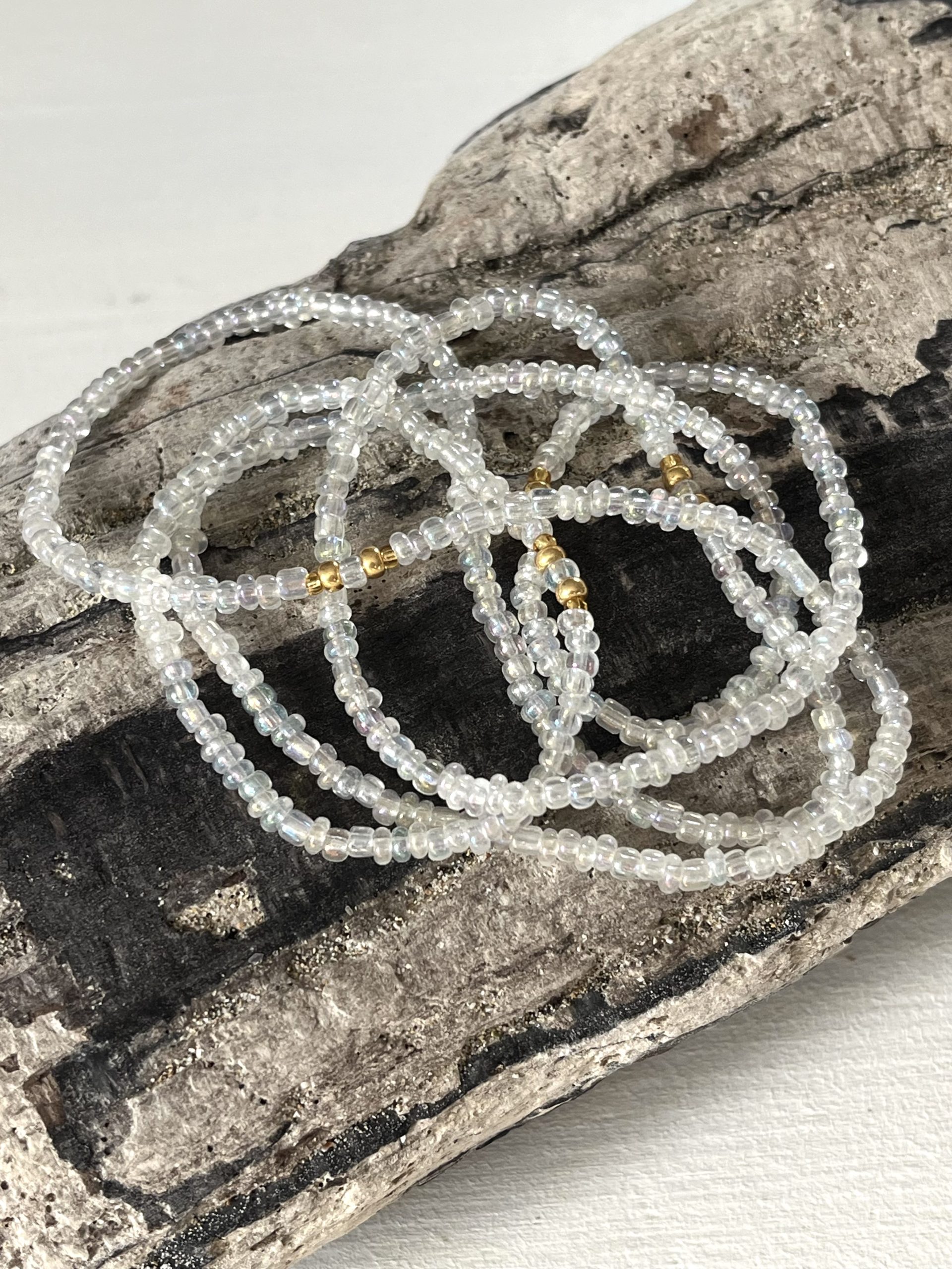 Baya ou bin bin élastique Soléia en perles de verre de coloris transparent cristal clear lumineux aux reflets lumineux et perles dorées japonaises miyuki très résistantes fait main et sur mesure ajusté a la ma taille bijou de l'été à porter autour de la taille