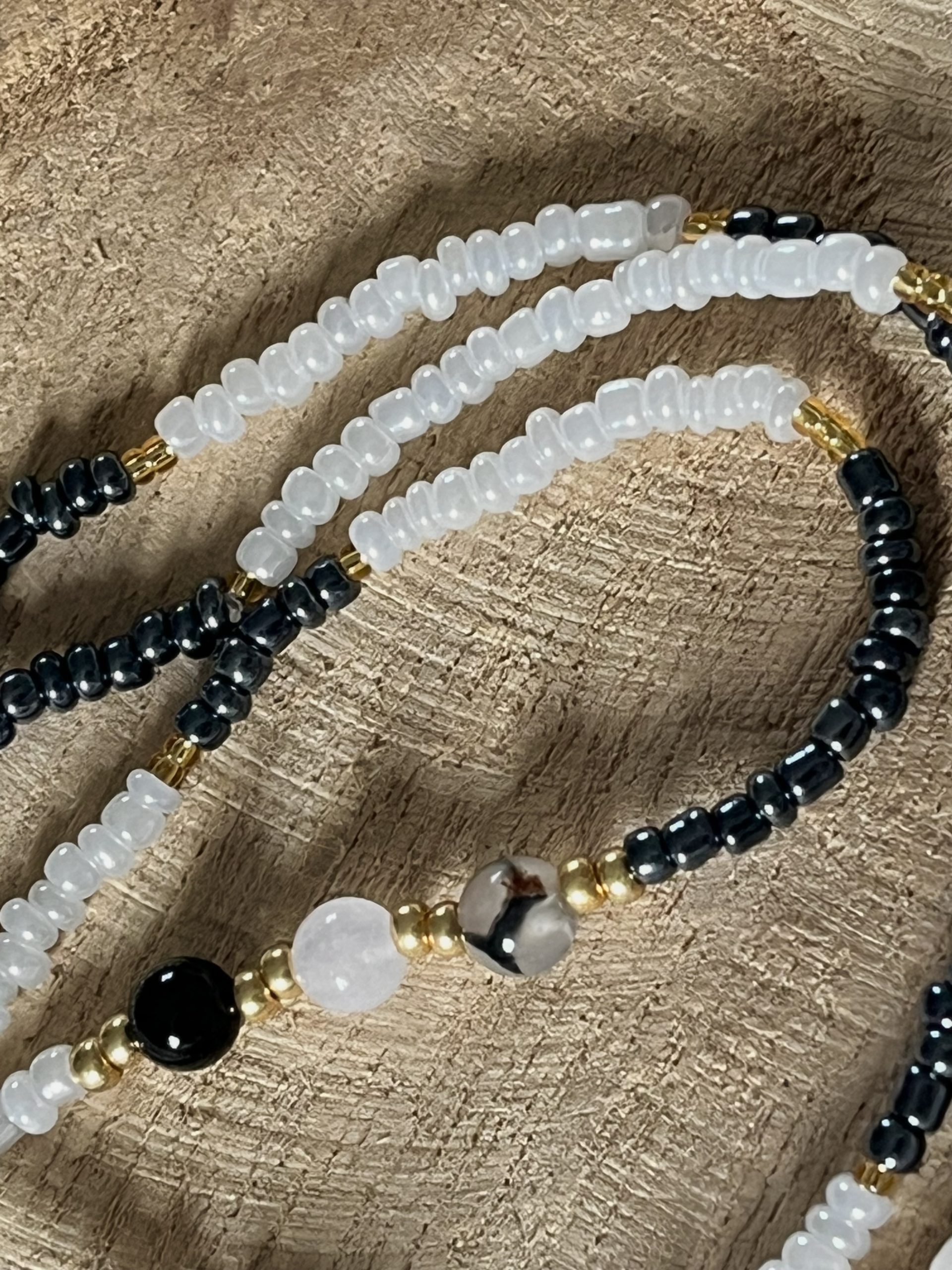 Baya bin bin élastique Soléia Tria en perles de verre gris foncé anthracite metallisées irisées nacré et perles de verre blanches et dorées japonaises miyuki et pierres naturelles agate veine de dragon onyx et jade quartz blanc transparent veritables fait main et sur mesure ajusté a la ma taille bijou de l'été à porter autour de la taille