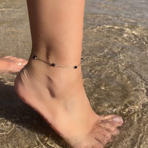 Finesse et éclat pour cette chevillère en perles de verre tissée sur un fil doré, avec fermoir en acier inoxydable doré