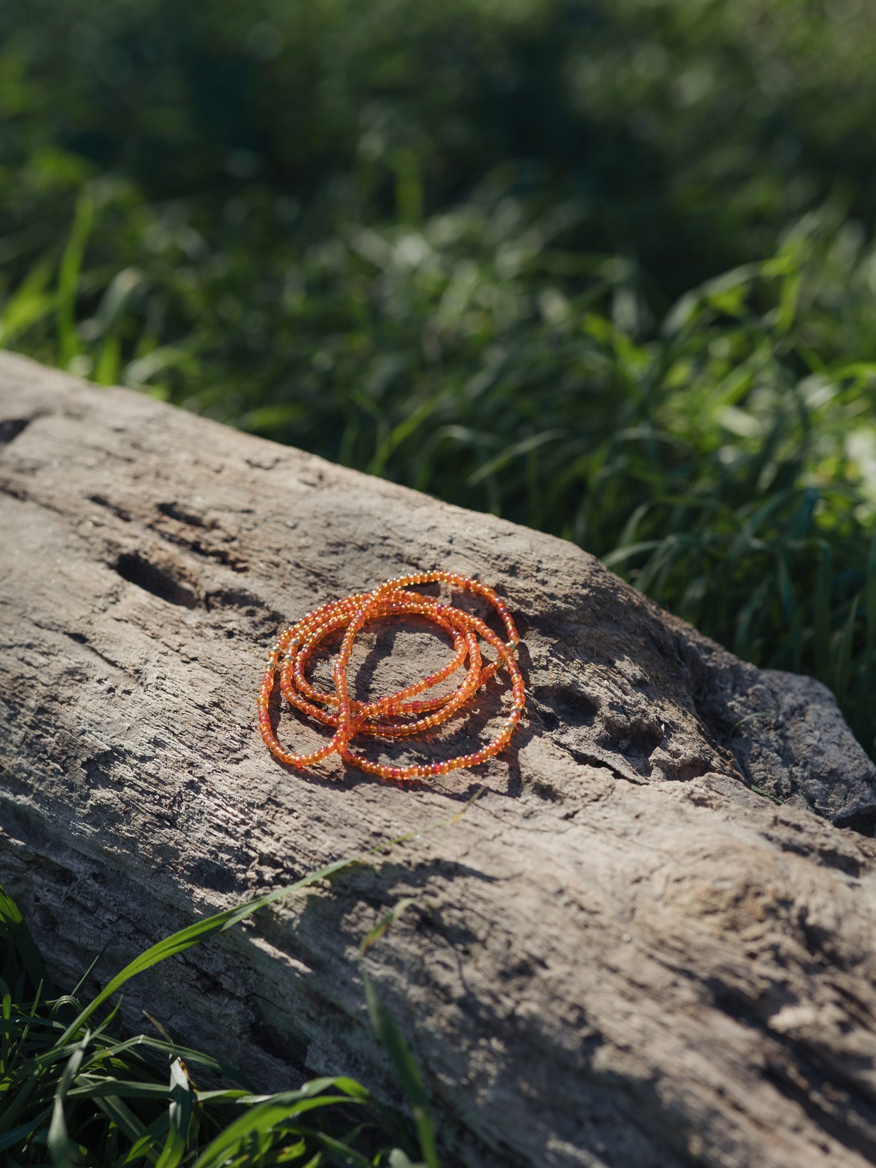Baya ou bin bin élastique Soléia en perles de verre de coloris orange incandescent aux reflets lumineux et perles dorées japonaises miyuki très résistantes fait main et sur mesure ajusté a la ma taille bijou de l'été à porter autour de la taille