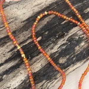 Baya ou bin bin élastique Soléia en perles de verre de coloris orange incandescent aux reflets lumineux et perles dorées japonaises miyuki très résistantes fait main et sur mesure ajusté a la ma taille bijou de l'été à porter autour de la taille