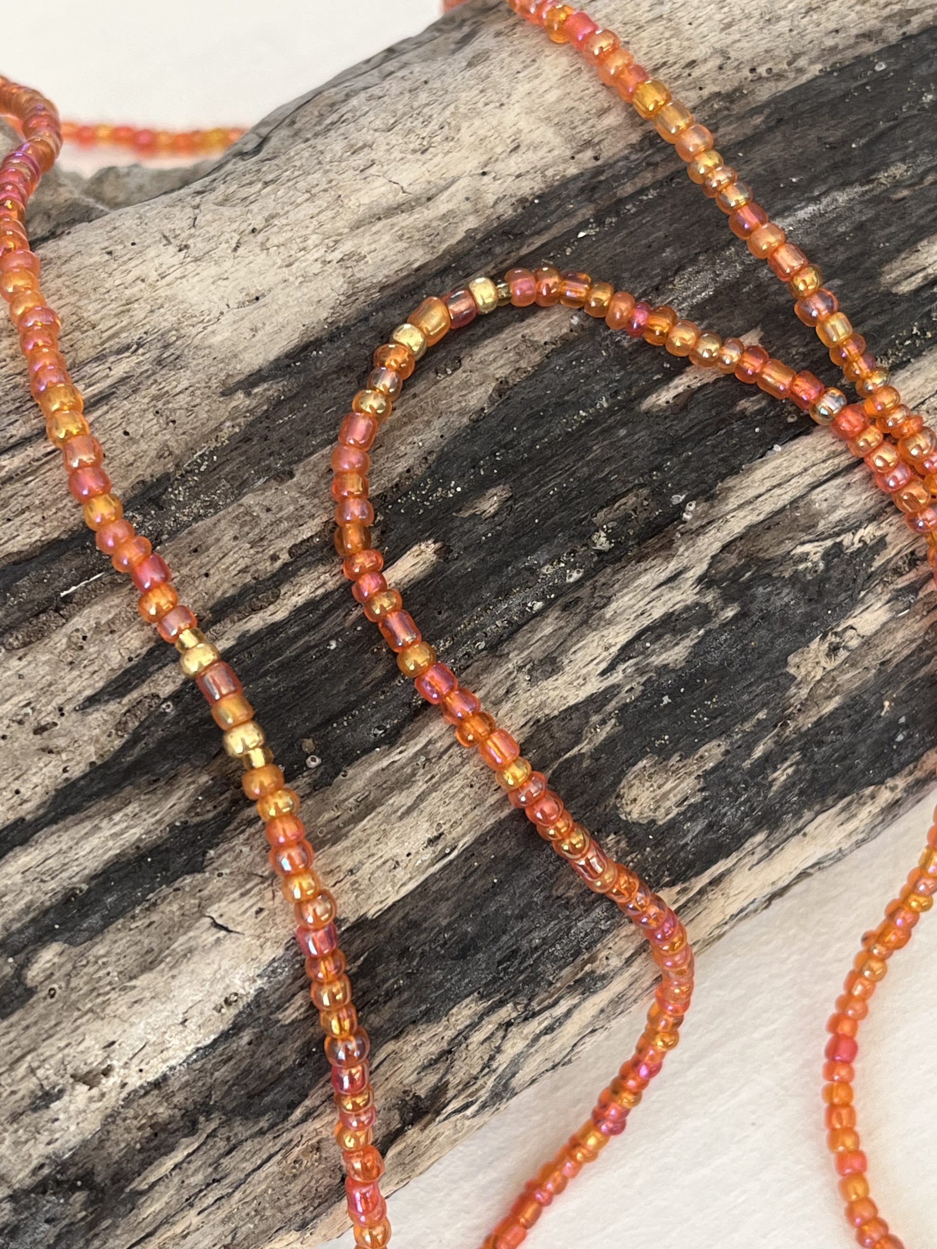 Baya ou bin bin élastique Soléia en perles de verre de coloris orange incandescent aux reflets lumineux et perles dorées japonaises miyuki très résistantes fait main et sur mesure ajusté a la ma taille bijou de l'été à porter autour de la taille