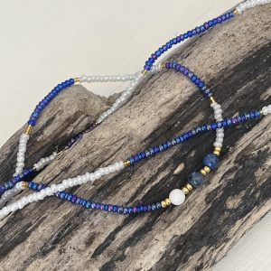 Baya bin bin élastique Soléia Tria en perles de verre bleu reflets violets lumineux éclatants nacré et perles de verre blanc blanches nacrées perles dorées japonaises miyuki pierres naturelles lapis lazuli sodalite et jade quartz blanc veritables fait main et sur mesure ajusté a la ma taille bijou de l'été à porter autour de la taille