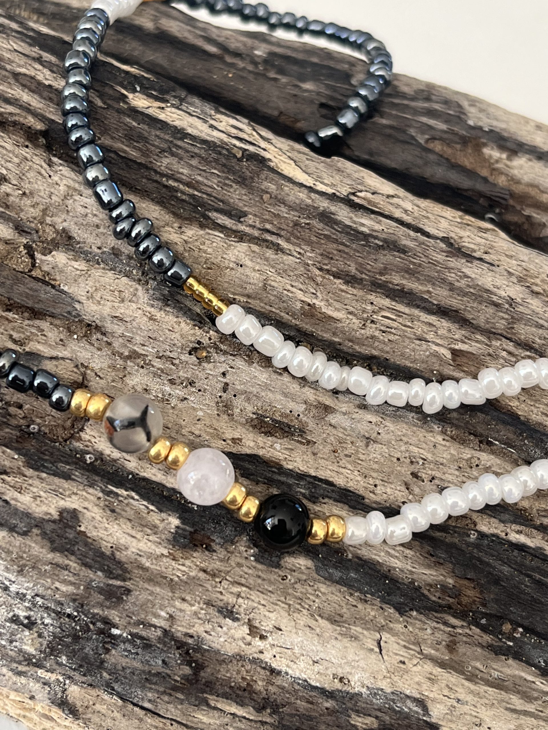 Baya bin bin élastique Soléia Tria en perles de verre gris foncé anthracite metallisées irisées nacré et perles de verre blanches et dorées japonaises miyuki et pierres naturelles agate veine de dragon onyx et jade quartz blanc transparent veritables fait main et sur mesure ajusté a la ma taille bijou de l'été à porter autour de la taille