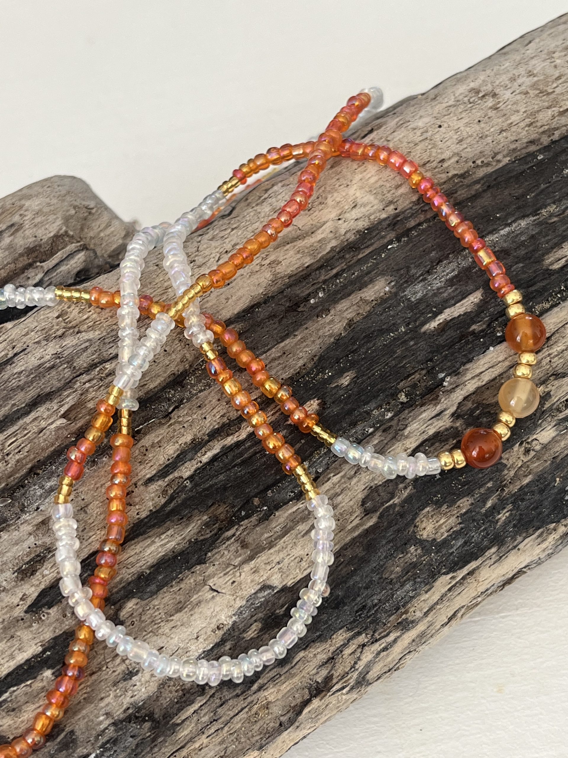 Baya bin bin élastique Soléia Tria en perles de verre orange vif reflets lumineux et perles transparentes cristal dorées japonaises miyuki et pierres naturelles agate cornaline veritables fait main et sur mesure ajusté a la ma taille bijou de l'été à porter autour de la taille