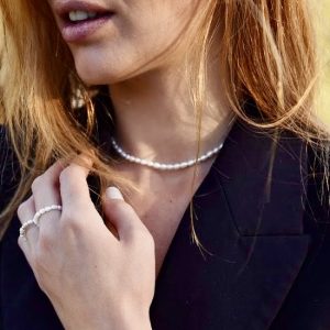 Le ras de cou Naïa est un collier en perles d'eau douce blanches féminin et doté d'un fermoir en acier inoxydable doré avec une chainette d'extension