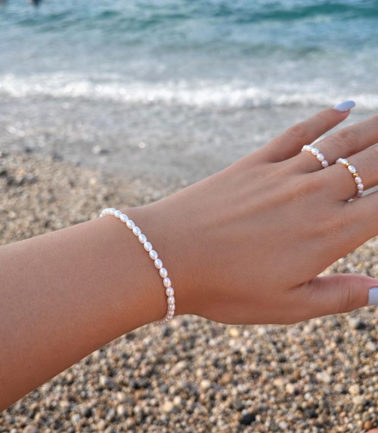 Bracelet Naïa féminin femme fille adolescente en petites perles de culture d'eau douce blanches véritables et fermoir en acier inoxydable doré avec chainette d'extension, médaillon les bijoux de Karine et bagues Naïa montées sur elastique solide